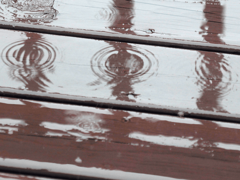 Raindrops making circles on the deck
